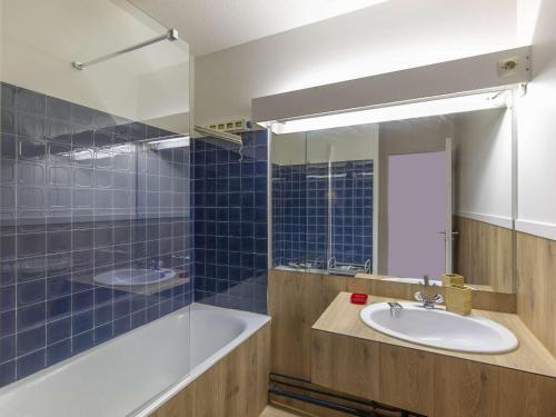 une salle de bain avec un lavabo, une baignoire et un miroir dans l'établissement Studio cabine 6 pers, pistes à proximité, balcon, cave à skis, cuisine équipée - FR-1-400-110, à Eaux-Bonnes