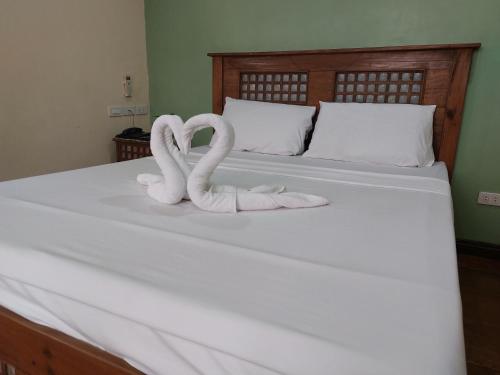 two white swans sitting on top of a bed at Makabata Guesthouse & Cafe in Manila
