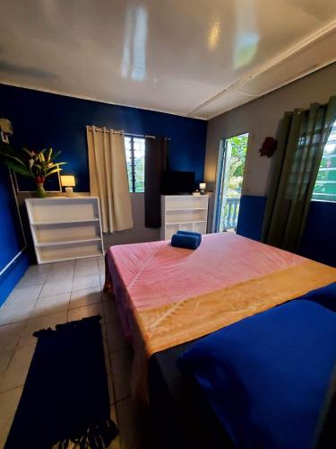 a bedroom with blue walls and a large bed at Hiaai in Haapu