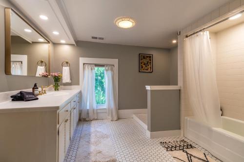 a bathroom with two sinks and a tub and a shower at The School House - Walk to all Shops and Restaurants - New Remodel in Manchester