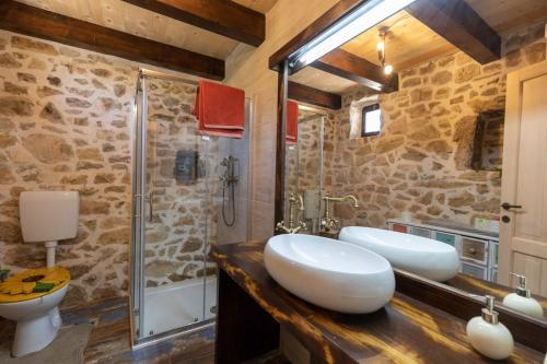 ein Bad mit 2 Waschbecken und einer Dusche in der Unterkunft Family friendly house with a swimming pool Bogatic, Krka - 17168 in Oklaj