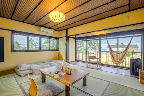 uma sala de estar com uma mesa e uma grande janela em Hamabe no Yado Asahiya em Himi