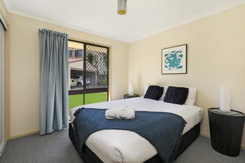 a bedroom with a large bed and a window at NAROO7- PRIME, CENTRE OF MOOLOOLABA LOCATION in Mooloolaba