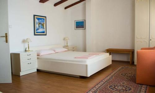 a bedroom with a white bed with pink pillows at Apartments and rooms by the sea Molunat, Dubrovnik - 17143 in Gruda