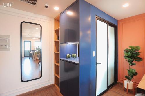 a kitchen with a blue wall and a mirror at Glese Balcony Seaview Apartment - FLC Sea Tower Quy Nhon in Quy Nhon