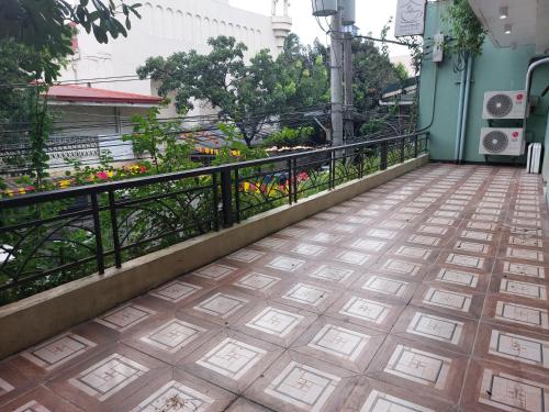 a balcony with a fence and a tile floor at Makabata Guesthouse & Cafe in Manila