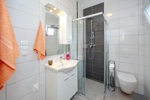 een witte badkamer met een wastafel en een douche bij Apartments by the sea Bibinje, Zadar - 17269 in Bibinje