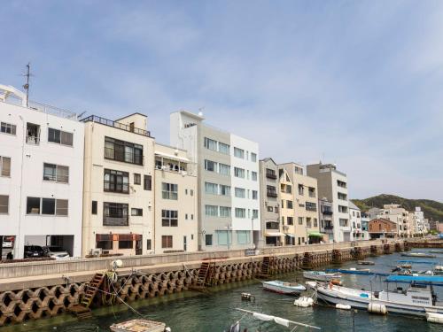 un grupo de barcos en un río con edificios en urashima INN - GANGI - en Onomichi