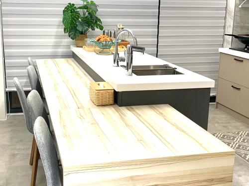 a kitchen with a sink and a wooden table at Jabez Homestay in Yilan City