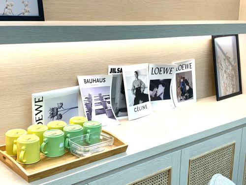 a shelf with a tray of cups and magazines at Jabez Homestay in Yilan City
