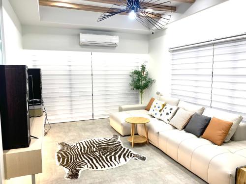a living room with a white couch and a zebra rug at Jabez Homestay in Yilan City