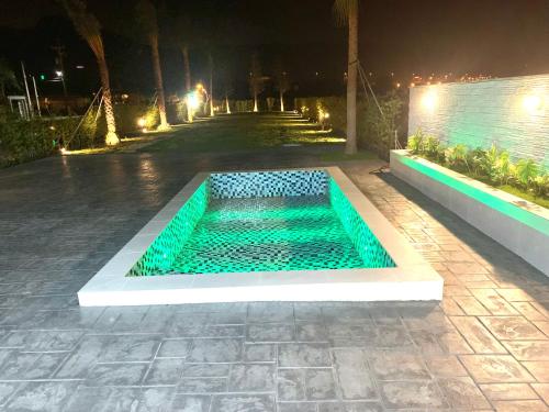 a swimming pool in the middle of a walkway at night at Jabez Homestay in Yilan City