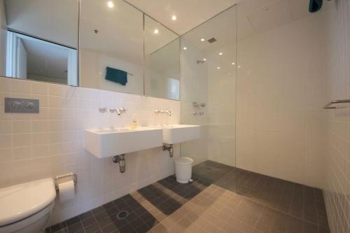 La salle de bains blanche est pourvue d'un lavabo et de toilettes. dans l'établissement Beachfront Air on Broadbeach, Amazing Views, à Gold Coast