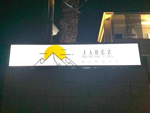 a sign on top of a building at night at Jabez Homestay in Yilan City
