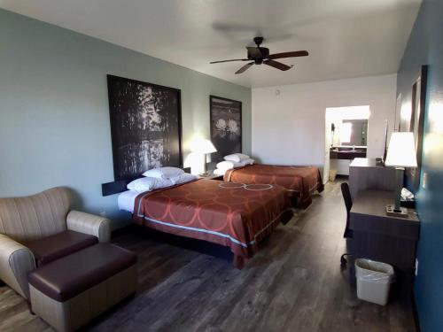 a hotel room with two beds and a ceiling fan at Super 8 by Wyndham Forney/East Dallas in Forney