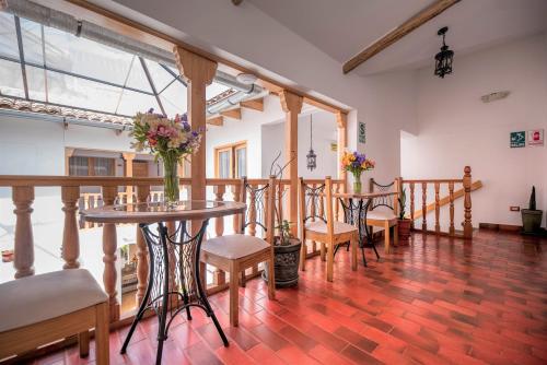 pokój z dwoma stołami i krzesłami z kwiatami w obiekcie Mistico San Blas Boutique w Cuzco
