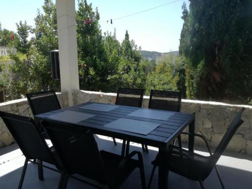 a black table and chairs on a patio with a view at Apartments by the sea Zatoglav, Rogoznica - 17321 in Rogoznica