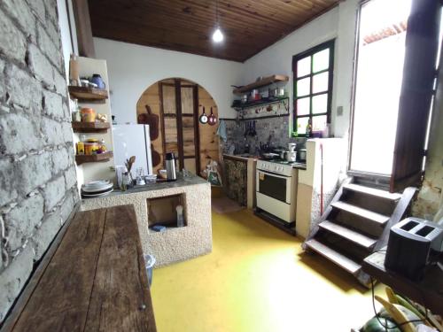 een keuken met een tafel, een fornuis en een koelkast bij Hostel Mucugê in Mucugê