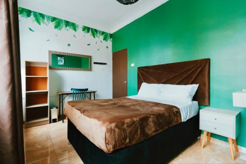 a bedroom with a bed with a green wall at The Secret Garden Hostel in Lima