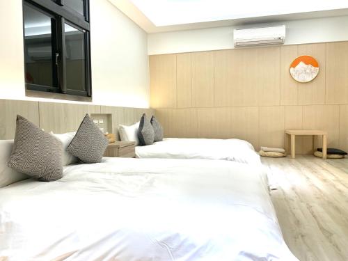 a bedroom with two beds and a clock on the wall at Jabez Homestay in Yilan City