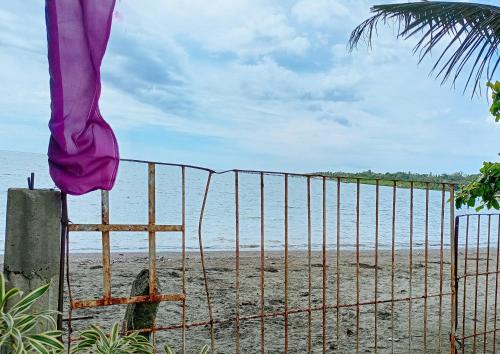 une clôture sur la plage à côté de l'océan dans l'établissement Erojo's Beach Resort, à Sindangan