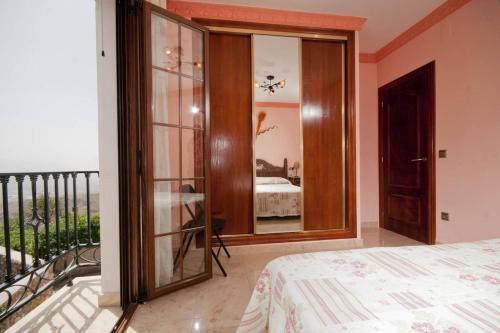 a bedroom with a balcony with a bed and a mirror at Casa Mamica Rosario in Yegen
