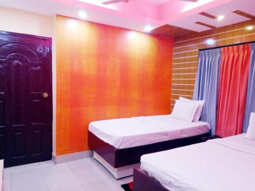 a bedroom with two beds and a wooden wall at Shopnonir Hotel & Restaurant in Chittagong