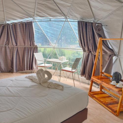 a room with a bed and a table in a tent at Evie Mae Camp in Ban Cha-om