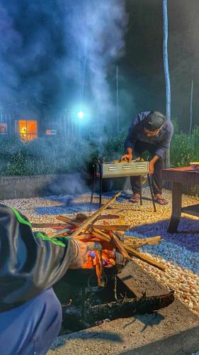 a man sitting at a picnic table with a grill at HANO Peak in Nāldera