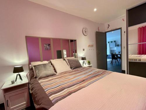 - une chambre avec un grand lit et une tête de lit violette dans l'établissement Vacances dans le Sud de la France, à Istres