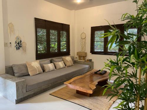 a living room with a couch and a coffee table at Chalisa Villas Koh Tao in Koh Tao