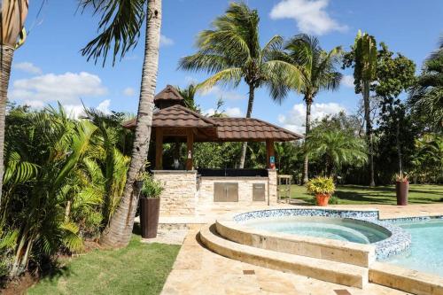 - une piscine avec un kiosque et des palmiers dans l'établissement New Sunny Villa With Pool Metro Country Club Juan Dolio, à La Puntica de Juan Dolio