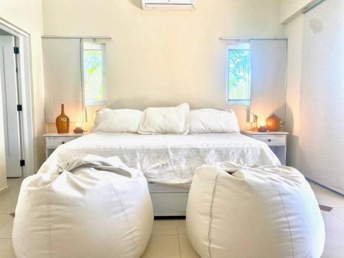 1 dormitorio con 1 cama blanca y 2 pufs en New Sunny Villa With Pool Metro Country Club Juan Dolio, en La Puntica de Juan Dolio