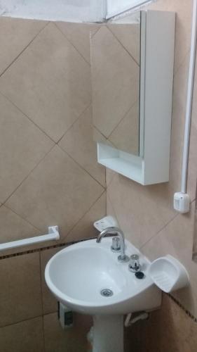 ein Badezimmer mit einem weißen Waschbecken und einem Spiegel in der Unterkunft 9 de julio in Villa Mercedes