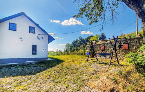 a white house with a playground in front of it at Cozy Home In Wilczyce in Wilczyce