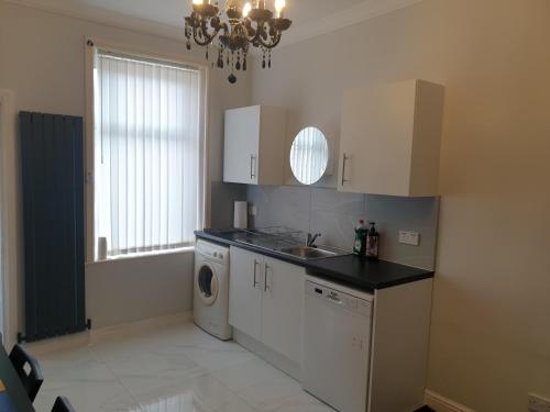 a kitchen with a sink and a washing machine at Gateshead's Amethyst 3 Bedroom Apt, Sleeps 6 Guests in Gateshead