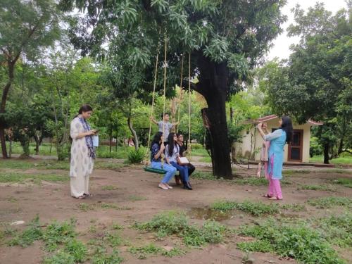 a group of people playing on a swing in a park at Ranakpur Nature Retreat in Sādri