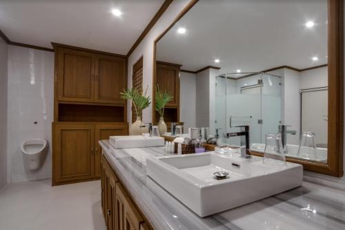 a bathroom with two sinks and a toilet at Istorya Forest Garden Resort 