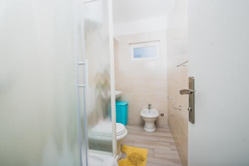 a bathroom with a toilet and a glass shower at Apartments by the sea Novalja, Pag - 17214 in Novalja