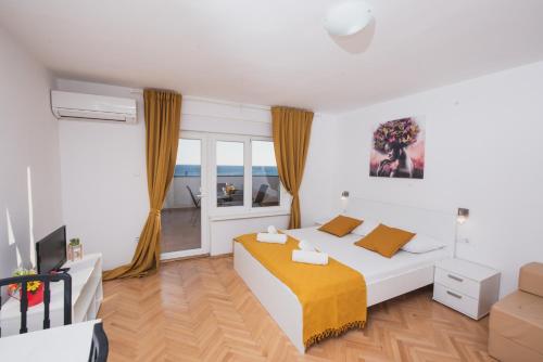 ein Schlafzimmer mit einem Bett und einem großen Fenster in der Unterkunft Apartments by the sea Novalja, Pag - 17214 in Novalja