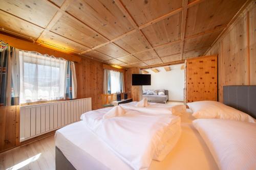 a room with three beds and a television in it at Landhaus Valtelas in Sölden