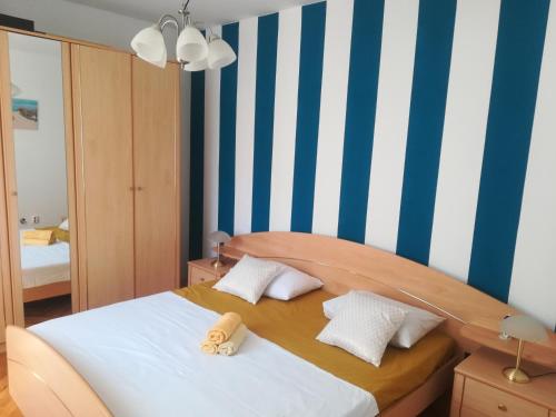 sypialnia z łóżkiem z niebieskimi i białymi paskami w obiekcie Apartments with a parking space Bibinje, Zadar - 17346 w Bibinje