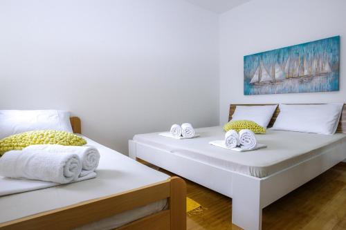dos camas sentadas una al lado de la otra en una habitación en Apartments with a parking space Novalja, Pag - 17364, en Novalja
