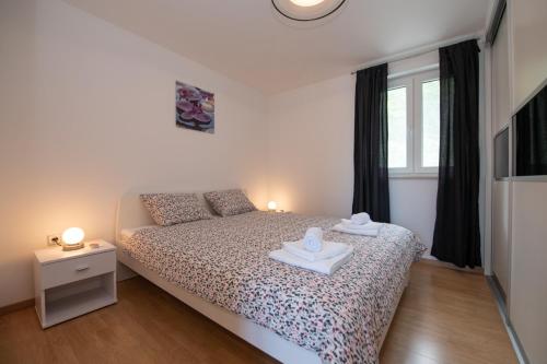 - une chambre avec un lit et 2 serviettes dans l'établissement Apartments with a parking space Liganj, Opatija - 17370, à Lovran