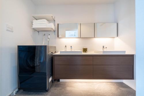 a bathroom with a sink and a vanity with a mirror at SETOUCHI SUP RESORT - Ao - in Shodoshima