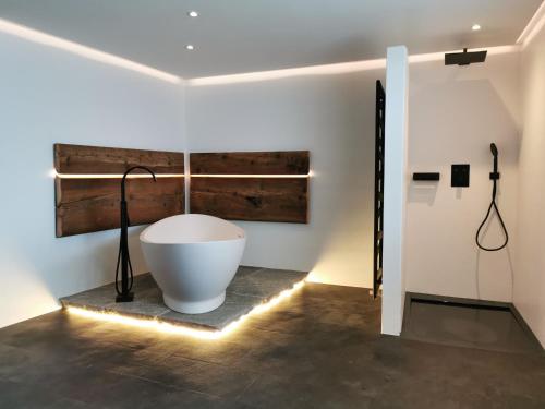 a bathroom with a bath tub on a floor with lights at Romantic standalone 5 room cottage in Valposchiavo in Poschiavo