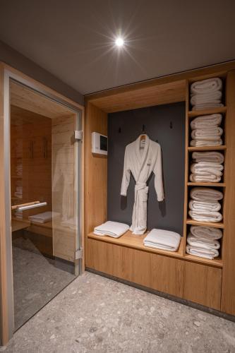 a room with a closet with a white shirt and towels at Goldbrunn in Oberstdorf