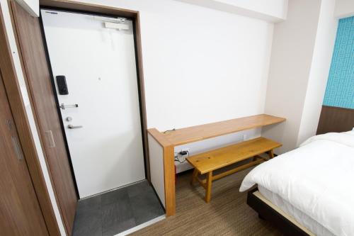 a small room with a bed and a sliding glass door at TOMMY CONDOMINIUM WAKASA 202 in Kume
