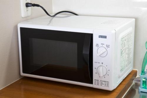 a white microwave oven sitting on top of a counter at TOMMY CONDOMINIUM WAKASA 202 in Kume