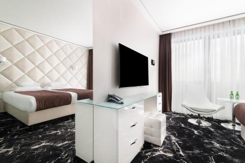 a hotel room with a bed and a tv at Odyssey ClubHotel Wellness & SPA Adults Only in Kielce